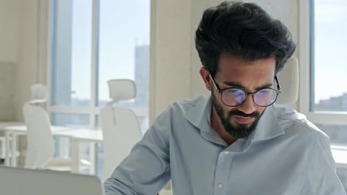 Man Working at Laptop in a Bright Office