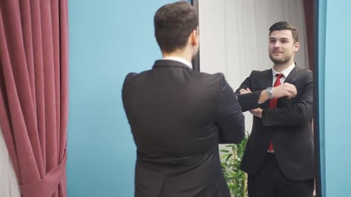 Man Adjusts Suit in the Mirror