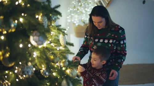 Mother and Son Decorating Christmas Tree at Home