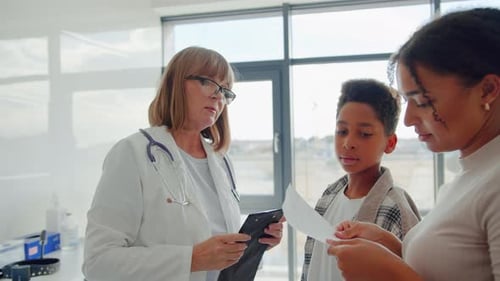 Doctor Consults with Child Patient and Parent