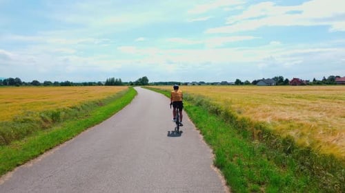 Man Riding Road Bike on Countryside Path During Sunny Day Cyclist Training