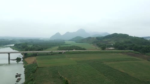 a Long Bridge Crosses the Big River Between the Valley and the Mountains in the Forest of Vietnam