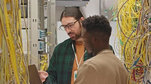 Server Room Employees Checking on Wires in Rack Server Cabinet