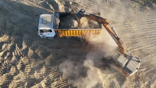 Excavator Loading Truck with Dirt on Site