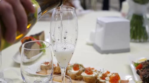 1. Um homem enche taças com champanhe. Celebração de casamento.