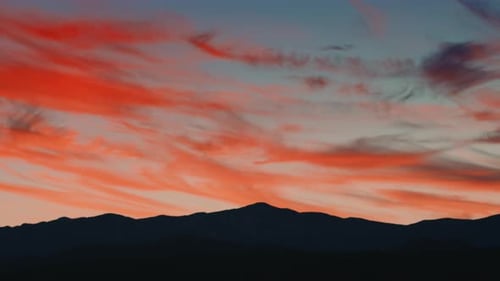 Vivid Sunset Behind Silhouetted Mountain Range