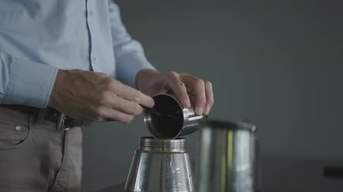 Man Adding Coffee Grounds to Moka Pot for Fresh Morning Brew. Artisanal Coffee Preparation Close-Up