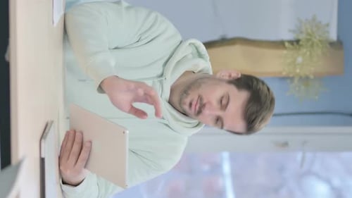 Vidéo verticale d'un jeune homme utilisant une tablette numérique
