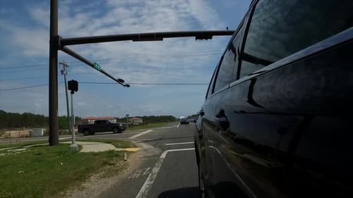 Car Driving on Paved Road in Daytime