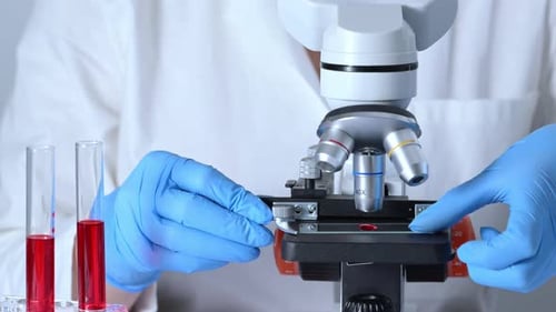 Scientist Analyzes Blood Sample with Microscope in Lab