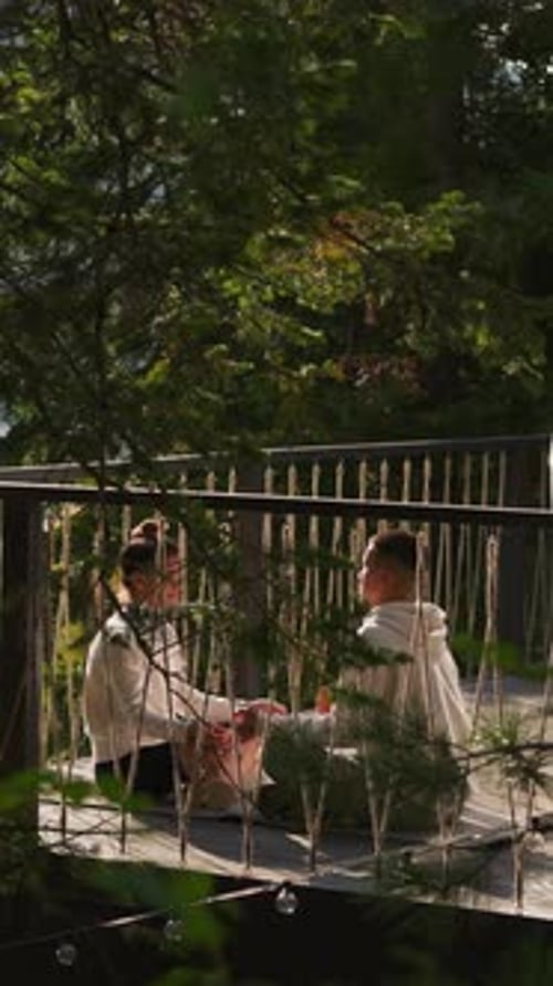 Young Couple Talking on Wooden Deck in Nature