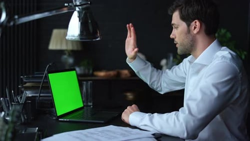 Handsome Businessman Video Calling Online on Laptop with Green Screen. Friendly Male