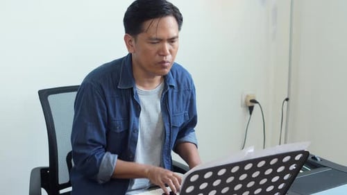 Man Plays Electronic Keyboard in Home Setting
