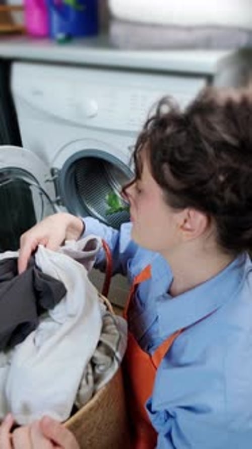 Woman checks clean laundry for wash quality after washing machine cycle, home laundry and routine ta