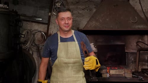 Man with Tools in Dark Rustic Blacksmith Workshop
