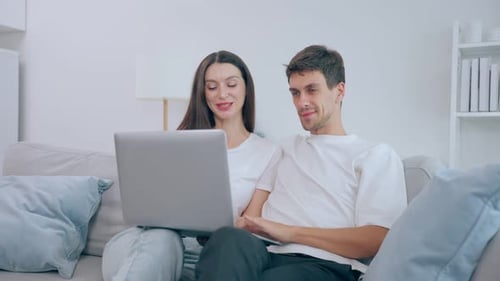 Couple Using Laptop Together on Couch at Home