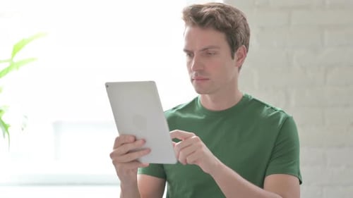 Young Adult Uses Tablet Indoors