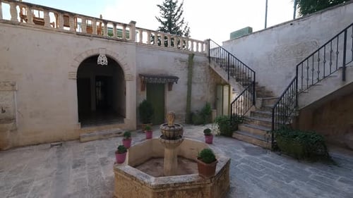 Ancient Stone Courtyard with Fountain in Urban Setting