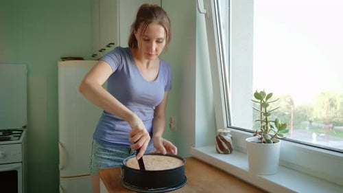Woman Removing Baked Pie From Pan with Knife in Kitchen Female Using Knife to Lift Freshly Baked Pie