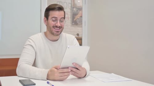 Middle Aged Man Doing Video Chat on Tablet in Office
