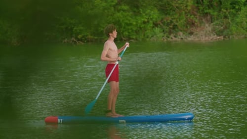 Teenager with Paddle on a Sup Floats on a Picturesque Lake Active Lifestyle Concept