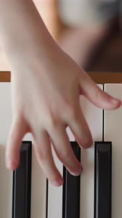 Child's Hand Playing Piano Keyboard, Close Up Shot
