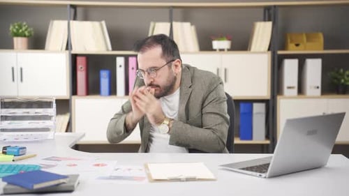 Stressed Man Working at Desk in Office