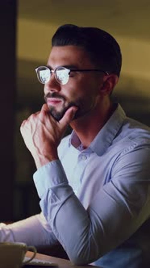 Thoughtful man working on computer at night