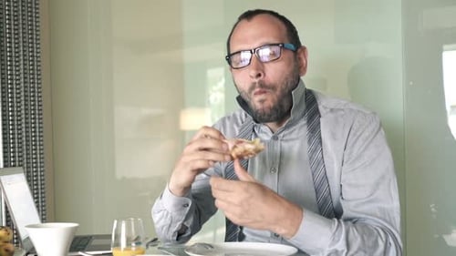 Man in shirt and tie eats pizza