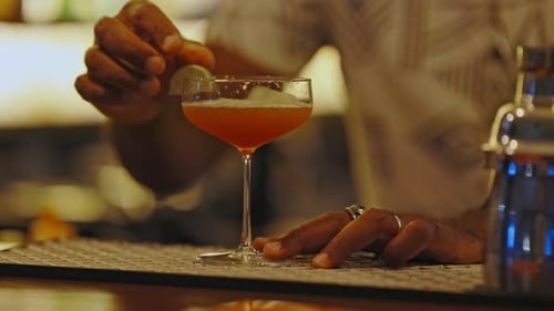 Bartender Garnish Cocktail Glass at the Bar