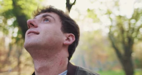 Close Up of Happy Smiling Young Caucasian Handsome Man Standing in Park on Sunny Autumn Day and