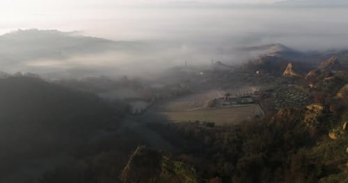 Aerial view of rolling hills and foggy valley, Italy.