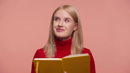 Young Woman Writing in Her Yellow Notebook