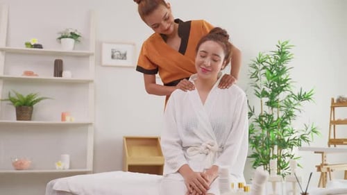 Schöne junge Frau bekommt Schulter- und Rückenmassage im Beauty Spa.