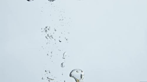 Bright Lemon Dropping Into Water with Bubbles