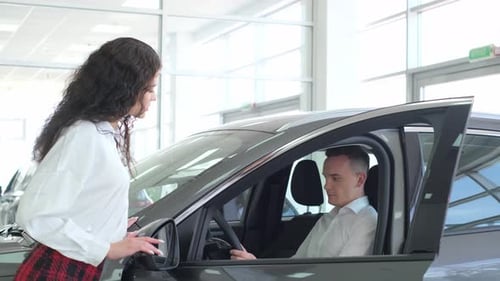 A Young Couple is Choosing a New Car at a Dealership Buying a Car on Credit