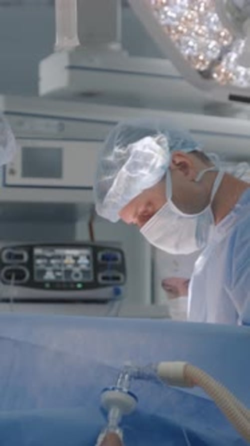 Male Surgeon Operates Patient with Colleagues