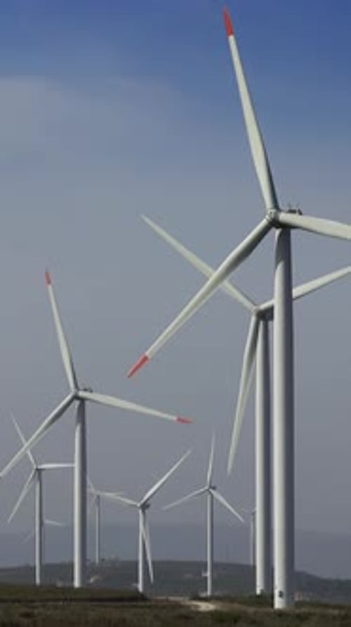 Windmills or wind turbine on wind farm in rotation