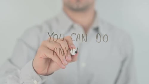 Person Writing 'You Can Do Anything' on Clear Surface