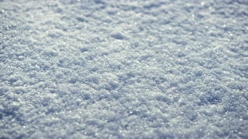 Sparkling White Snow Crystals Covering Ground Wintertime Close Up. Texture of Smooth