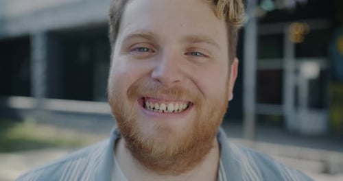 Closeup of Overjoyed Young Man Laughing Having Fun Enjoying Joke Against City Background