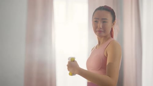 Woman Lifting Weights for Exercise Indoors