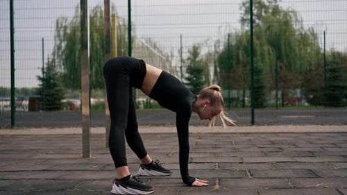 Woman Warming Up Stretching Outside Urban Area