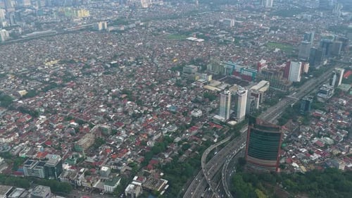 Aerial view over dense jakarta suburbs and modern cityscape