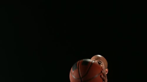 Man Shooting Basketball on Black Background