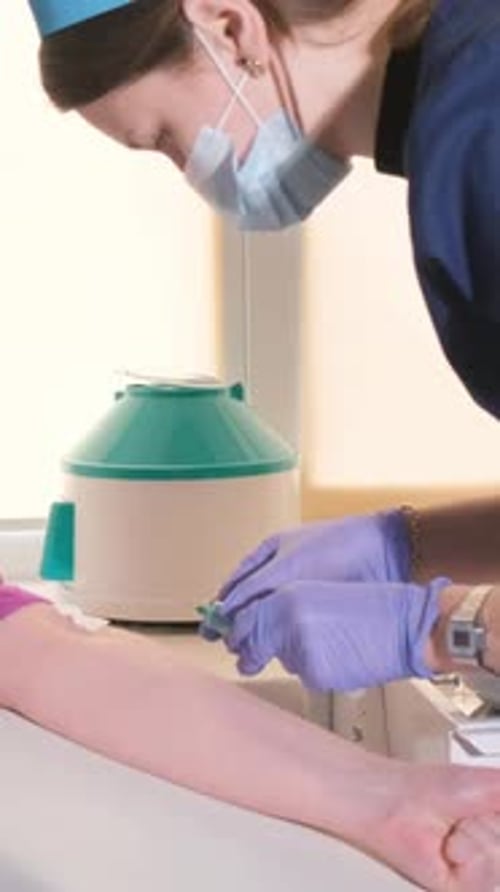 Medical Professional Draws Blood Sample in Hospital Setting