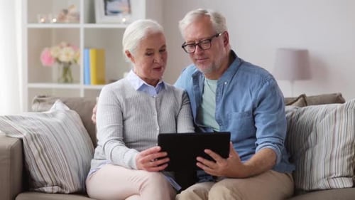 Senior Couple Using a Tablet Together on Couch