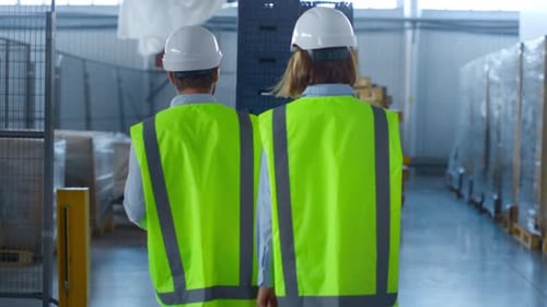 Factory Supervisors Inspecting Warehouse Analysing Production Process Talking. Two Professional M...