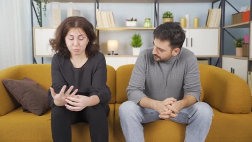 Woman Returning Ring to Man on Couch