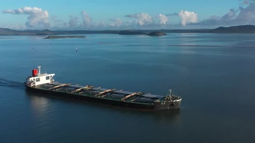 Drohnenschwenkaufnahme eines großen Kohleschiffs, das den Hafen verlässt, Gladstone, Queensland, Australien. 4K